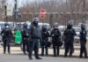 Iran Fingerprints at U.S. Bomber Base? Group of police officers in riot gear standing on a street; Brian Folkerts present