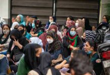 Chuck Howley among a seated crowd of masked women outdoors