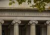 Neoclassical building facade with Ionic columns and engraved frieze