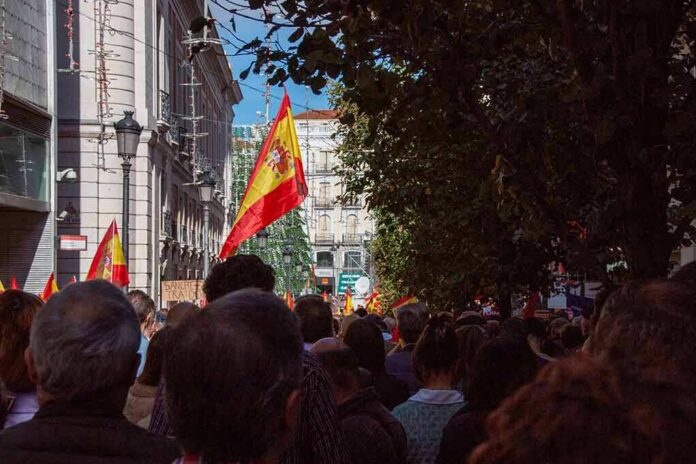 shutterstock_2387482013 Crowd with Spanish flags in a city street