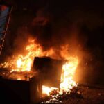 Burning dumpster and debris at night