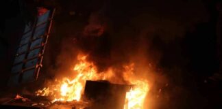 Burning dumpster and debris at night