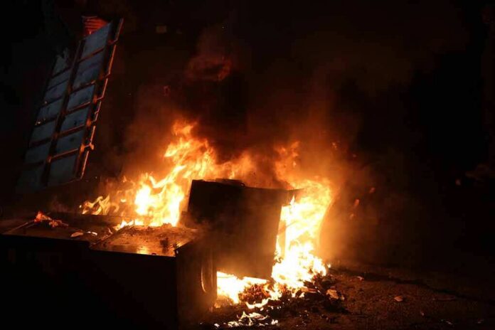 Burning dumpster and debris at night
