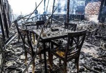 Burned dining tables and chairs in a fire-damaged building