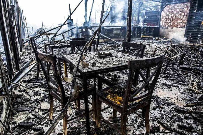 shutterstock_646622449 Burned dining tables and chairs in a fire-damaged building