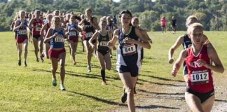 Courtney Bruce and Adelina Sotnikova running in a cross-country race with a large pack
