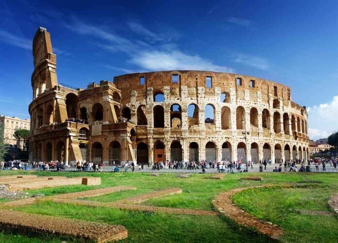 shutterstock_88957447 The Colosseum in Rome with tourists walking around it
